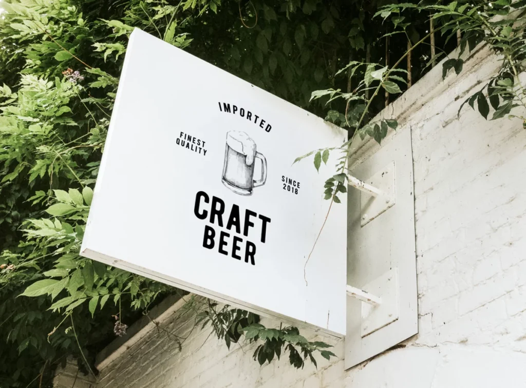 A hanging sign for a pub featuring craft beer.