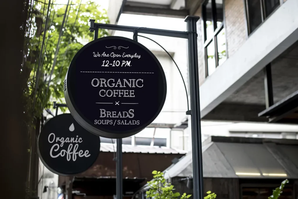 A hanging circular sign promoting a coffee shop.