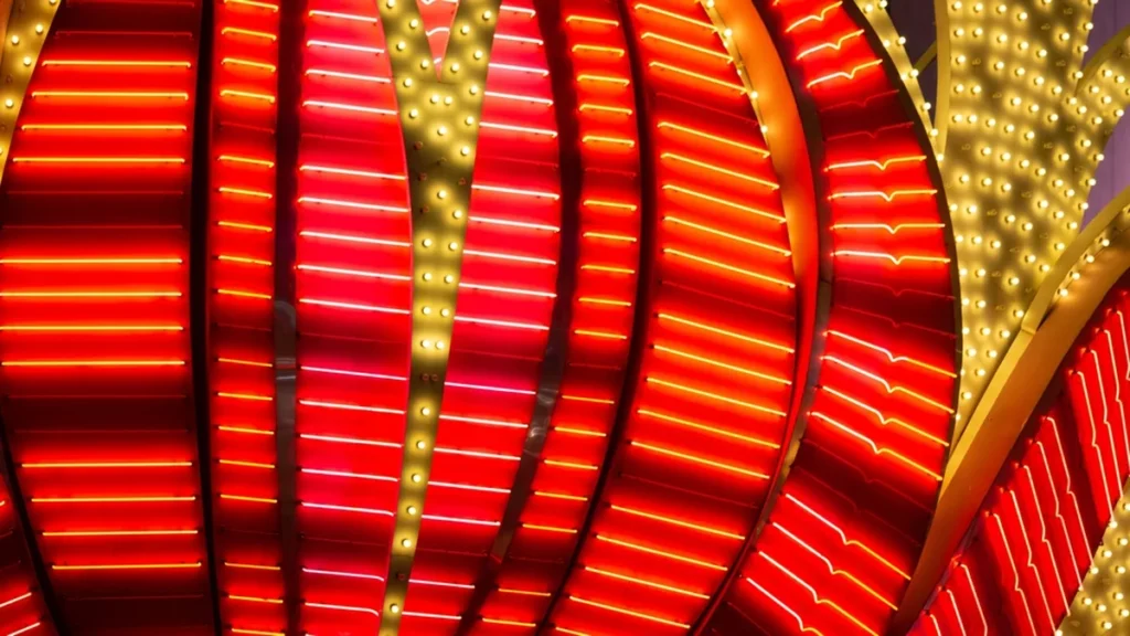 Neon signage in Vegas, mostly white, gold, and yellow neon on a red background.