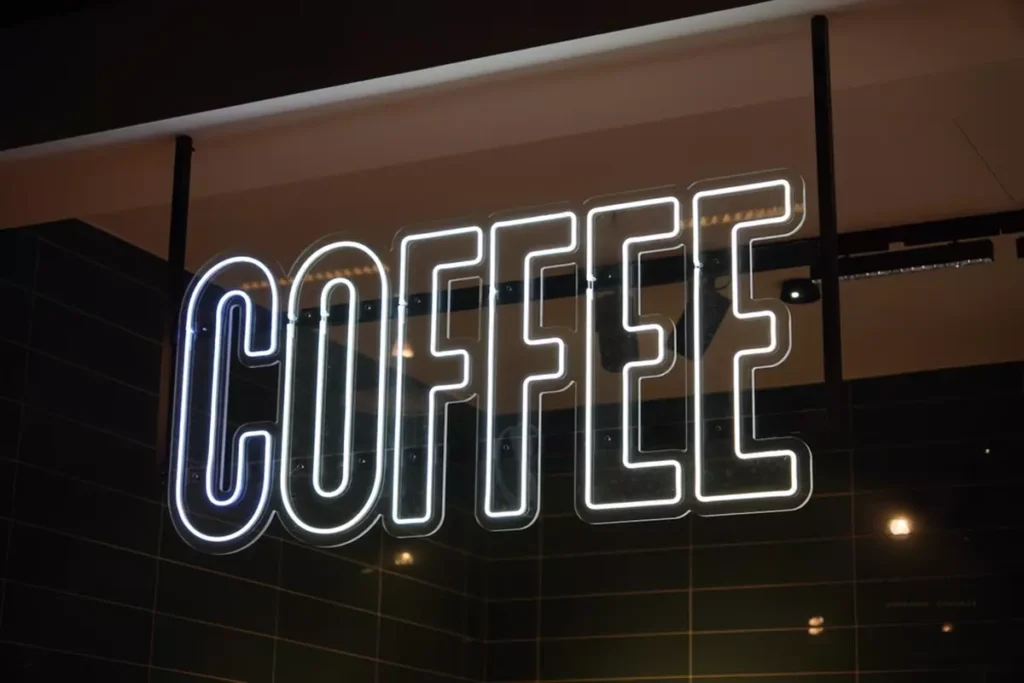 A neon block-letter sign that spells out 'COFFEE.'
