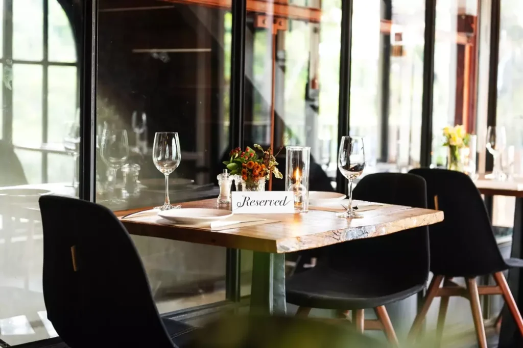 A two-top table at a nice restaurant, with table settings and a 'Reserved' tag.
