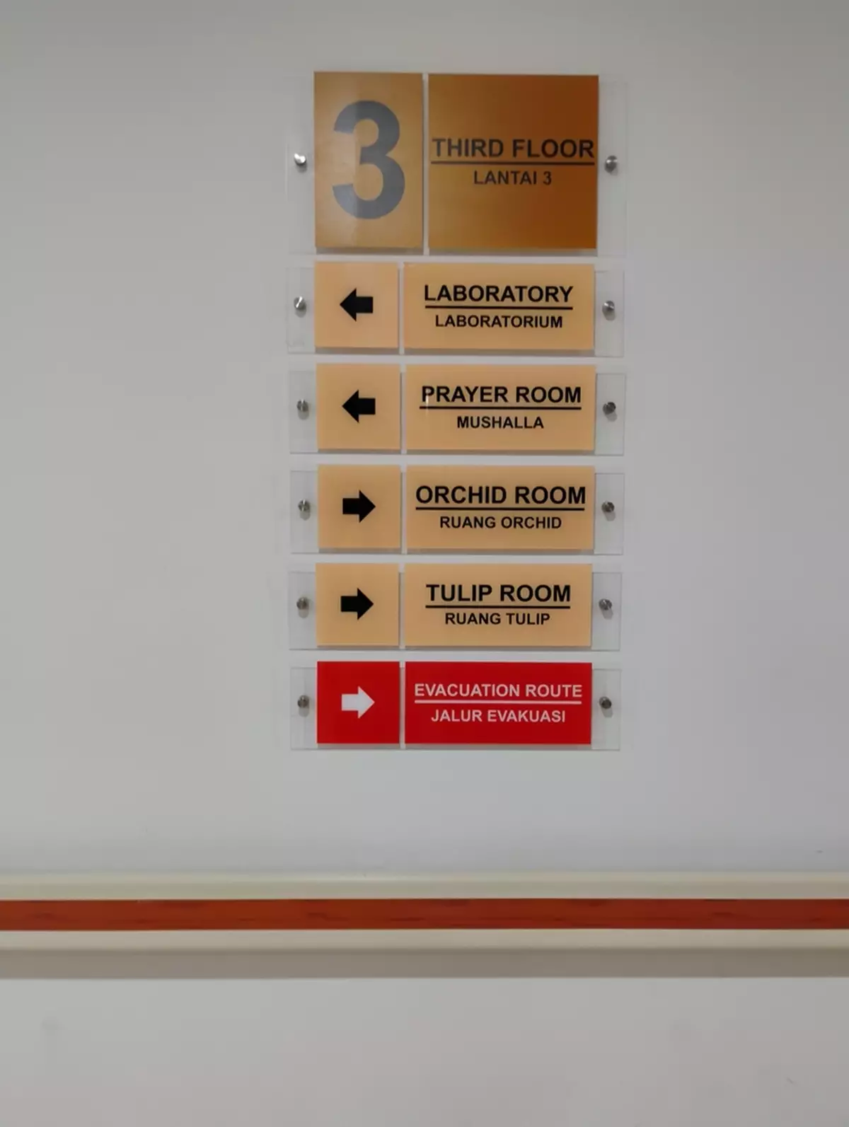 Directional/wayfinding signs in an office corridor.