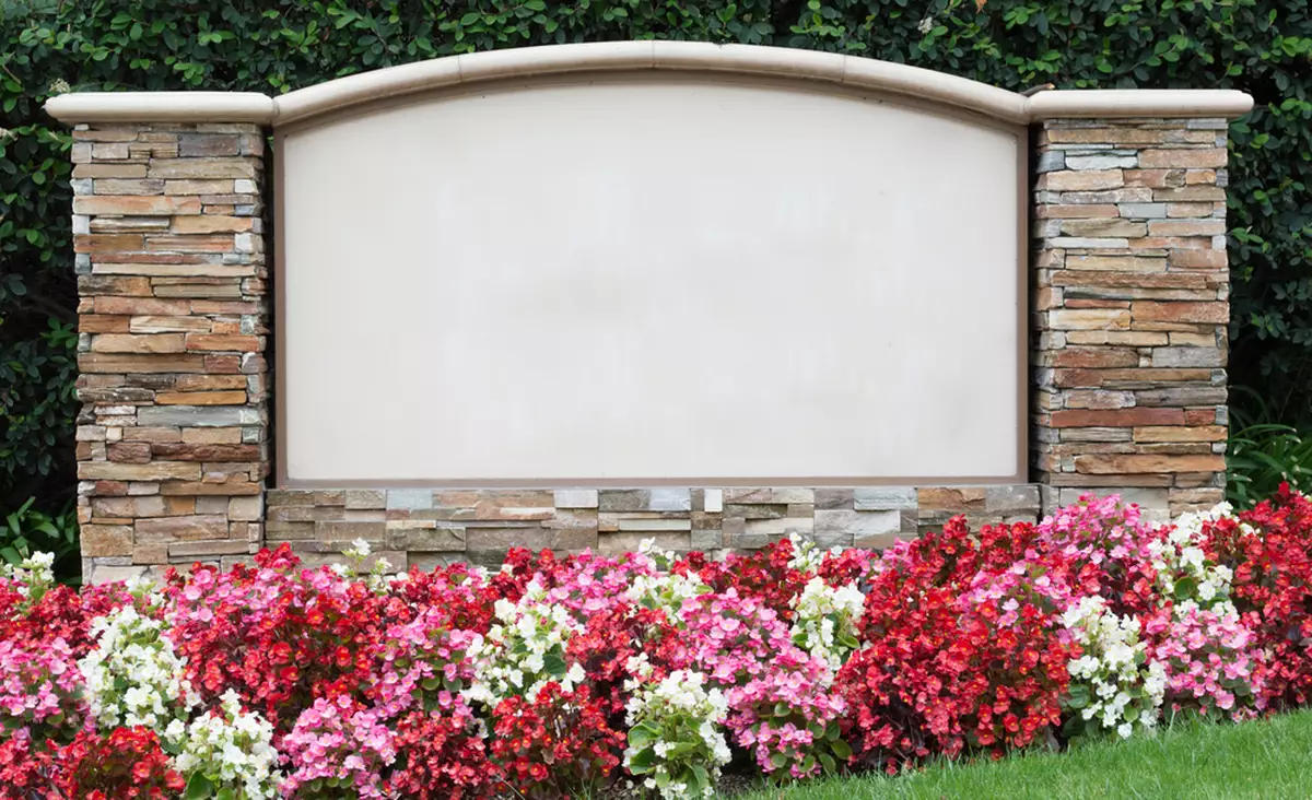 Monument sign placed between two pillars of stacked stone.