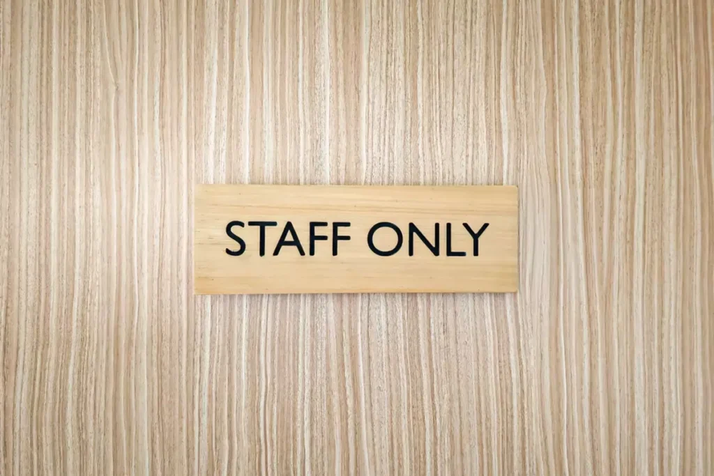 A wooden-looking sign that reads 'STAFF ONLY.'
