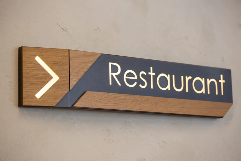 A closeup of a hotel sign plate 'Restaurant' on the wall.