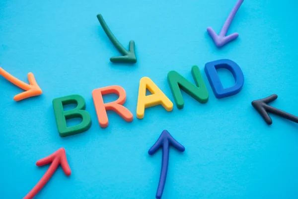Brand identity image featuring the word BRAND in all-caps big letters (all different colors), surrounded by arrows.