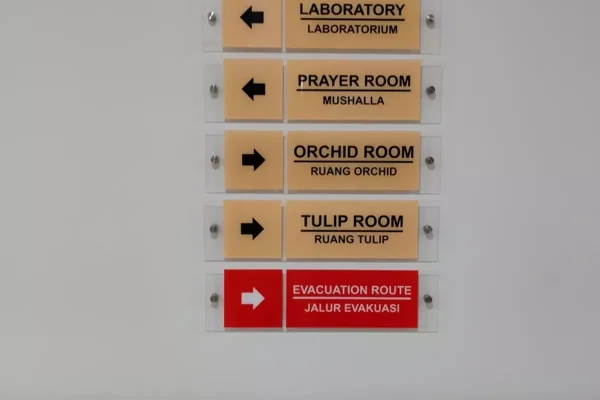 Directional/wayfinding signs in an office corridor.