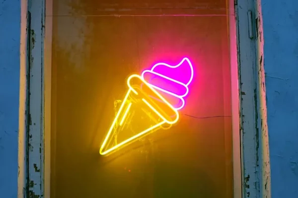 A neon sign in the shape of an ice cream cone with soft serve.