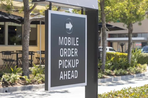 Outdoor directional signage pointing customers toward mobile order pickup.
