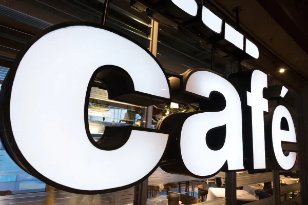 A coffee shop’s pan channel sign that reads 'cafe' in lowercase block letters.
