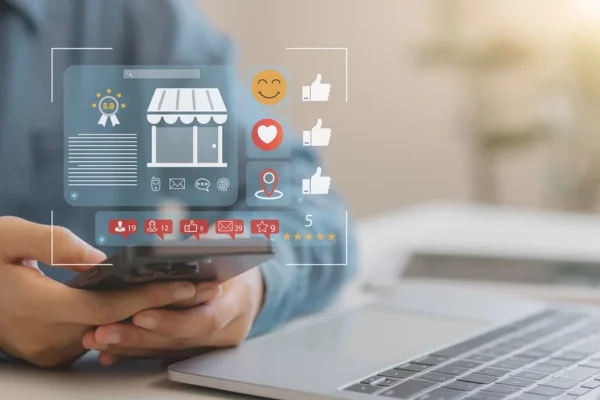 Concept image of small business marketing. Icons of social media likes, et al superimposed over a hand holding a phone.