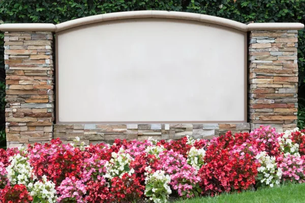 Monument sign placed between two pillars of stacked stone.